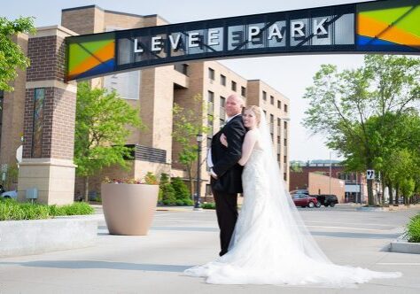 A man and woman posing for a picture under a sign.