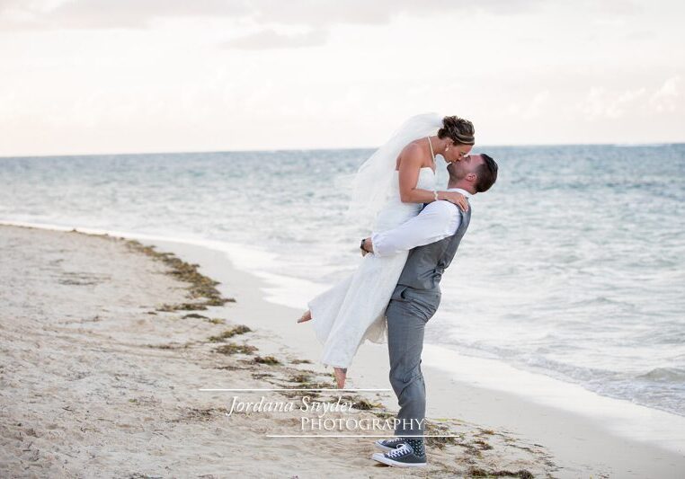 A man and woman kissing on the beach