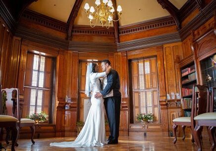 A bride and groom kissing in the middle of their wedding day.