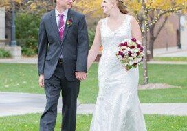 A man and woman walking in the grass.