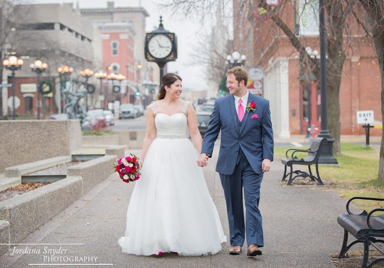 A bride and groom walking down the street